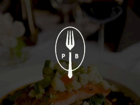 The image features a fork and spoon logo with the letters "P" and "B," placed over a background showing a plated dish and glassware.