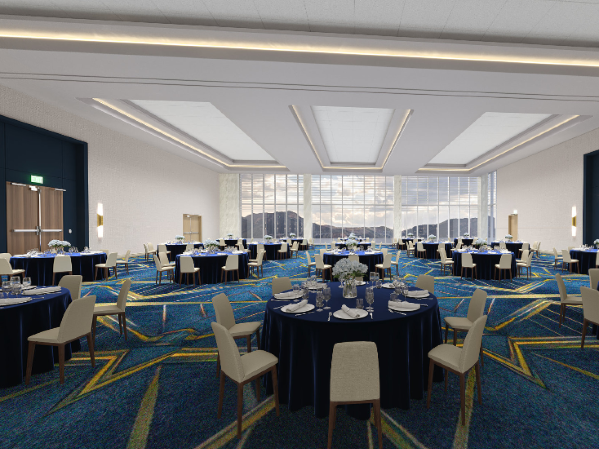 The image depicts a spacious, well-lit banquet hall set with round tables covered with navy blue tablecloths and white chairs, ready for an event.