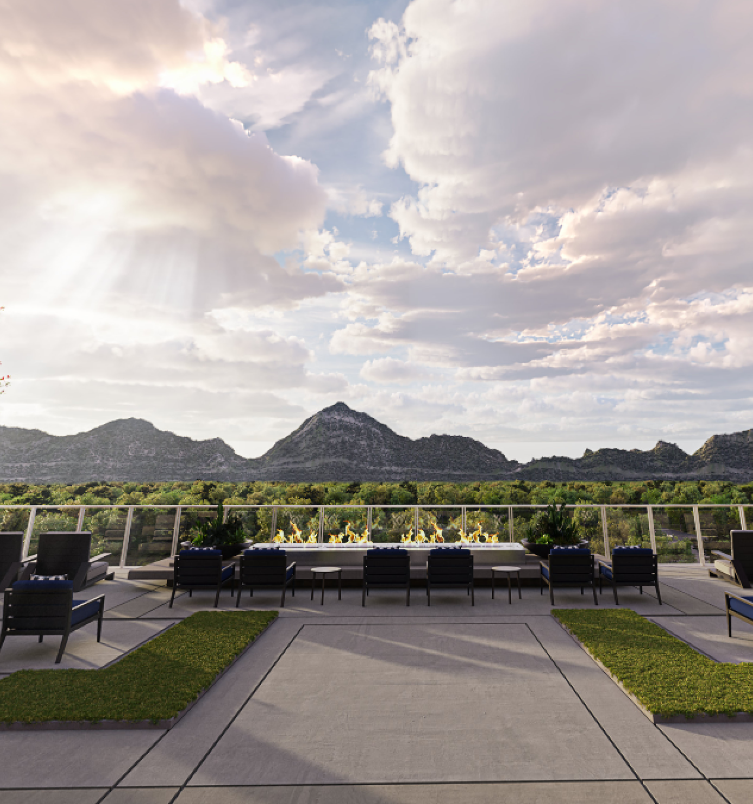 A rooftop terrace with modern outdoor seating, trees with reddish leaves, and a scenic view of mountains under a partly cloudy sky.